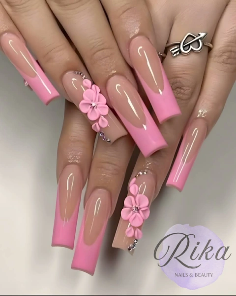 Female hands showing newly done nails with transparent and pink colours and flower designs