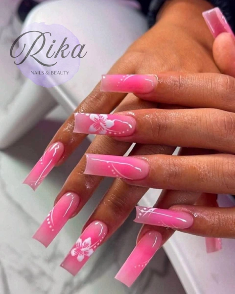 Hands showing newly designed nails of pink and white flowers