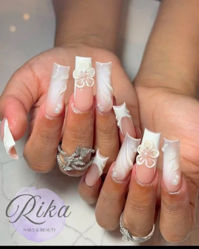 female hands showing white nails with flowers on them
